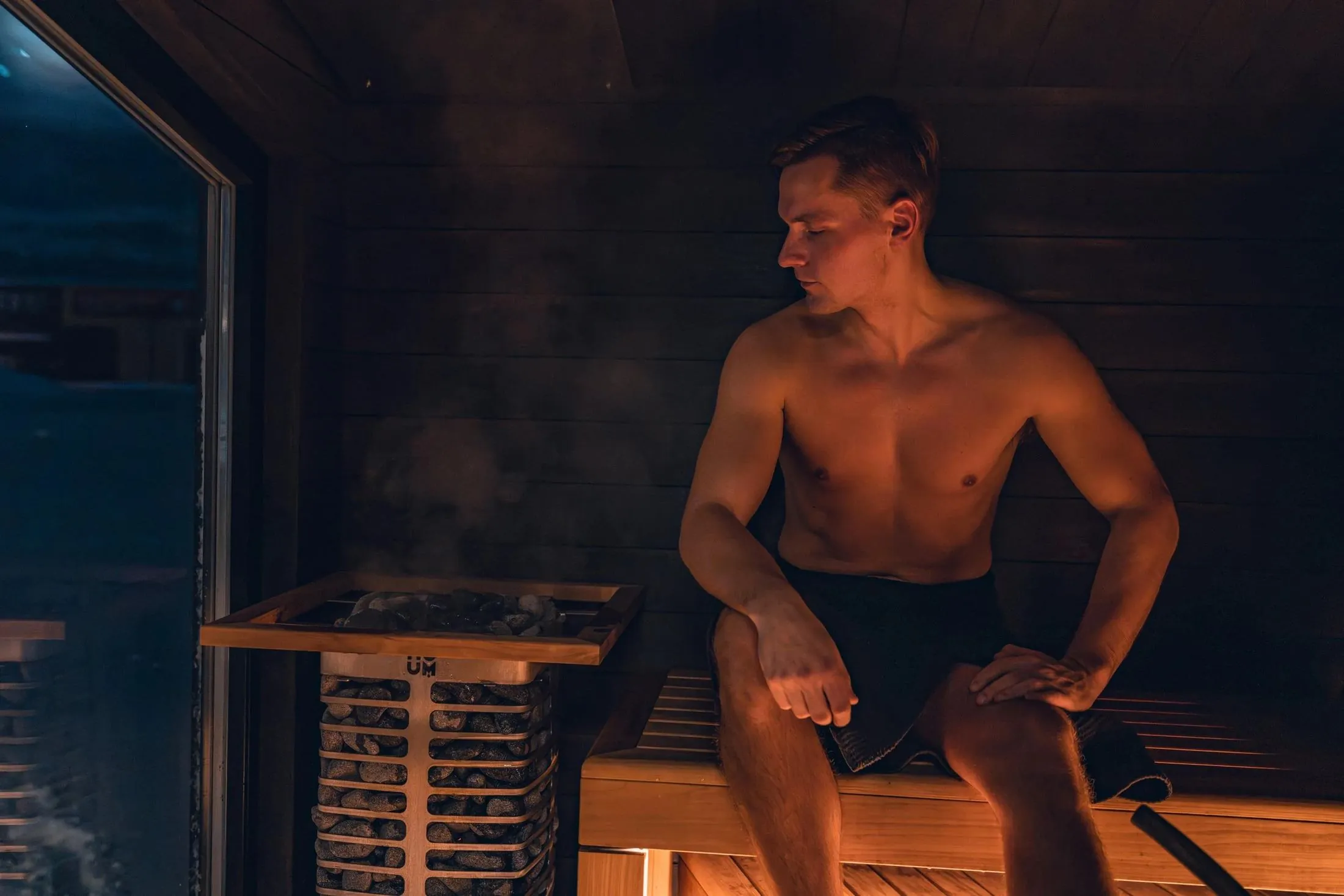 A man relaxing in a dimly lit sauna